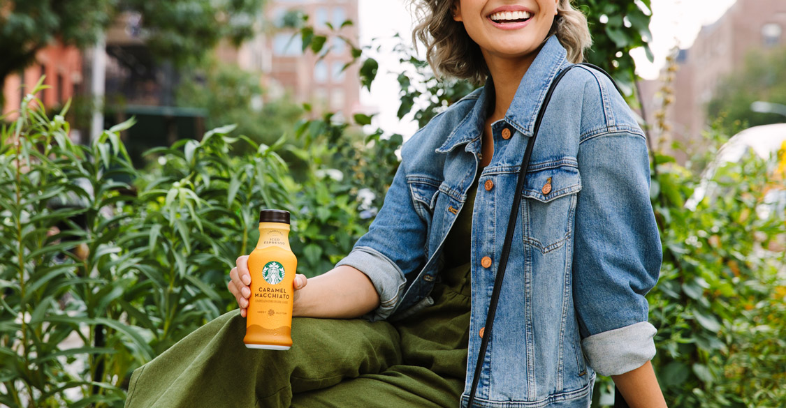 Woman holding a Starbucks bottled drink